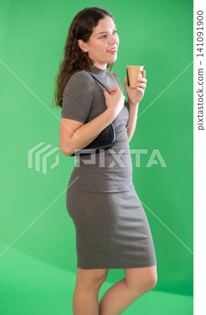 Young woman drinking coffee in front of green screen Young woman drinking coffee in front of green screen 141091900