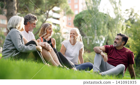 Seniors friends relaxing and laughing in park Seniors friends relaxing and laughing in park 141091935