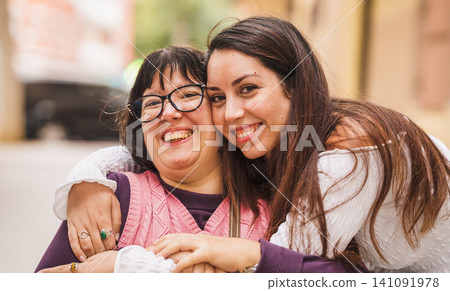 Women with disability embracing, showing inclusion and support Women with disability embracing, showing inclusion and support 141091978
