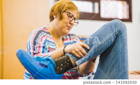 Physiotherapist working with patient on leg exercise Physiotherapist working with patient on leg exercise 141092030