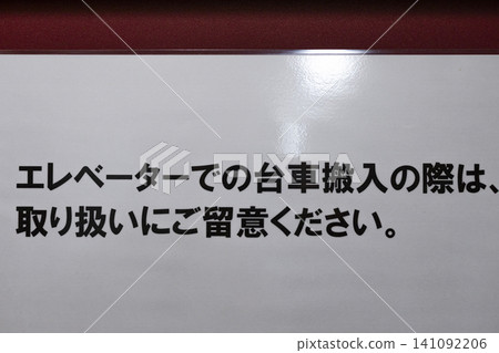 Laminated warning sign regarding bringing carts into the elevator. 141092206
