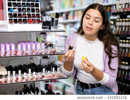 Happy girl testing new nail varnish in cosmetics shop Happy girl testing new nail varnish in cosmetics shop 141092216