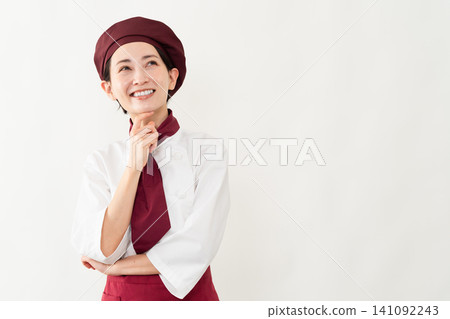 A woman wearing a baker's uniform A woman wearing a baker's uniform 141092243