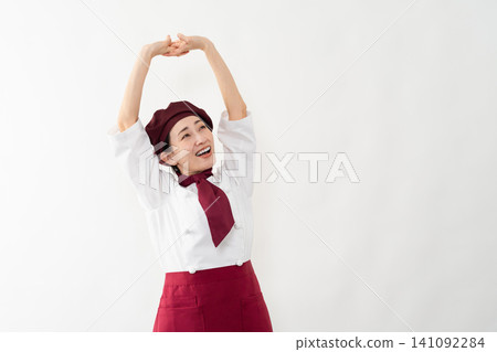 A woman wearing a baker's uniform 141092284