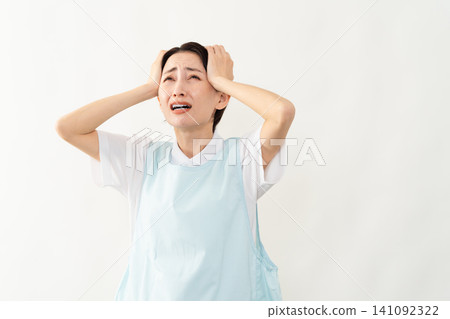 A woman wearing a light blue apron; a caregiver image. 141092322