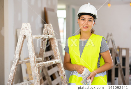 Portrait of positive woman builder during repair works Portrait of positive woman builder during repair works 141092341