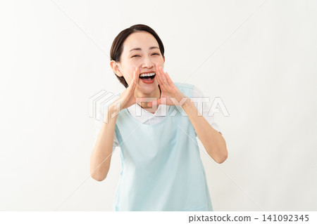 A woman wearing a light blue apron; a caregiver image. A woman wearing a light blue apron; a caregiver image. 141092345