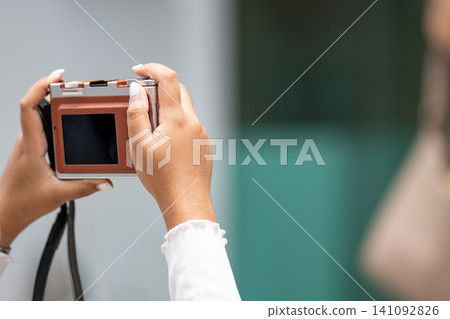 woman hands holding a compact digital camera is taking a photo with copy space. woman hands holding a compact digital camera is taking a photo with copy space. 141092826
