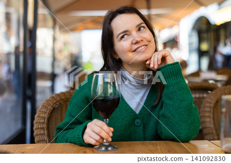Young adult woman drinking wine at restaurant Young adult woman drinking wine at restaurant 141092830