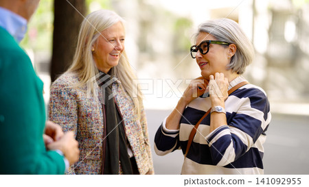 Senior women friends talking laughing outdoors Senior women friends talking laughing outdoors 141092955