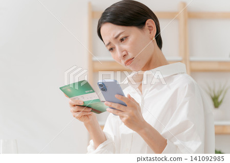 A woman who falls down looking at a passbook A woman who falls down looking at a passbook 141092985