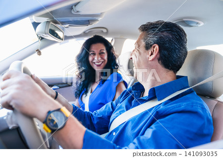 Mature couple driving car celebrating road trip 141093035