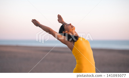 Woman practicing yoga stretching on beach during sunset Woman practicing yoga stretching on beach during sunset 141093077