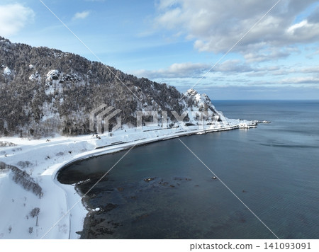 Cape Kitami Kamui and its lighthouse stand amidst the snow-covered plains of the Okhotsk Sea in winter. Cape Kitami Kamui and its lighthouse stand amidst the snow-covered plains of the Okhotsk Sea in winter. 141093091