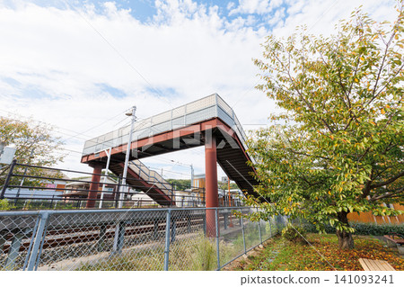 A pedestrian overpass connecting platforms at a local train station. A pedestrian overpass connecting platforms at a local train station. 141093241