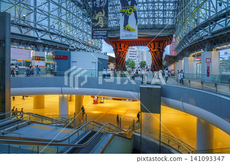 Kanazawa, Japan - Oct 6 2024, panoramic view of the east entrance of Kanazawa Station, with Tsuzumi-mon Gate in the background, in evening, with people walking on a background, Kanazawa, Japan Kanazawa, Japan - Oct 6 2024, panoramic view of the east entrance of Kanazawa Station, with Tsuzumi-mon Gate in the background, in evening, with people walking on a background, Kanazawa, Japan 141093347