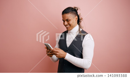 Young latino man smiling using smartphone Young latino man smiling using smartphone 141093388