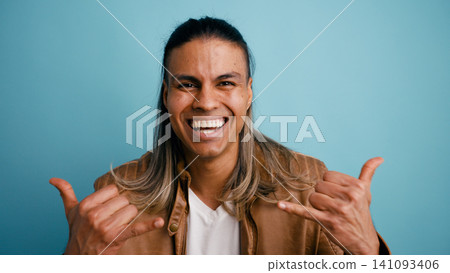 Happy latino man making shaka sign gesture 141093406