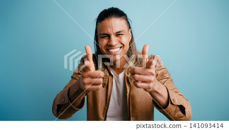 Latino man smiling making finger guns gesture Latino man smiling making finger guns gesture 141093414