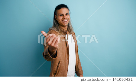 Smiling latino man beckoning with hand gesture Smiling latino man beckoning with hand gesture 141093421
