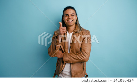 Latino man smiling giving thumbs up gesture Latino man smiling giving thumbs up gesture 141093424