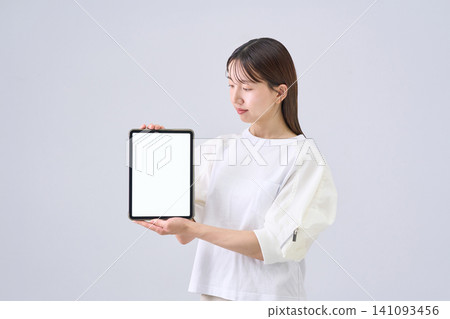 Japanese woman showing tablet screen Japanese woman showing tablet screen 141093456