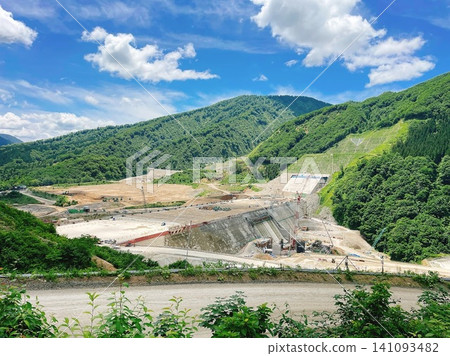 A panoramic view of a large-scale dam construction site in a mountainous area. A panoramic view of a large-scale dam construction site in a mountainous area. 141093482