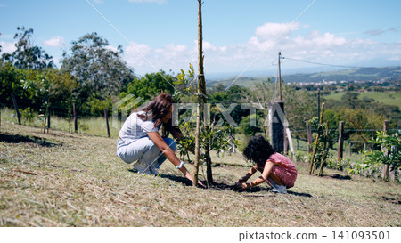 Latina mother and daughter planting tree for sustainability Latina mother and daughter planting tree for sustainability 141093501