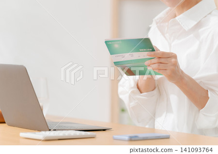 The woman's hands as she looks at her bankbook The woman's hands as she looks at her bankbook 141093764