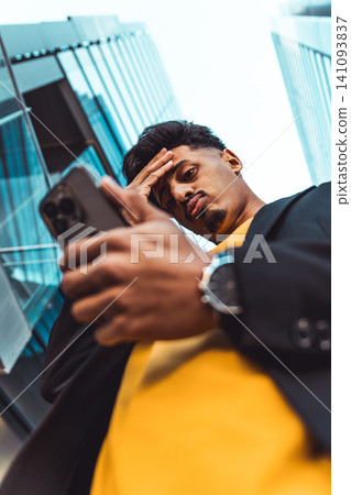 Moroccan man experiencing work stress using smartphone Moroccan man experiencing work stress using smartphone 141093837