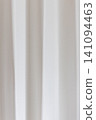 Beautiful white curtain fabric texture background with vertical pleats and soft shadows. 141094463