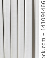 Beautiful white curtain fabric texture background with vertical pleats and soft shadows. 141094466