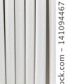 Beautiful white curtain fabric texture background with vertical pleats and soft shadows. 141094467