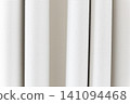 Beautiful white curtain fabric texture background with vertical pleats and soft shadows. 141094468
