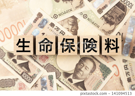 一塊標示「人壽保險費」的鈔票和大量10,000日圓面額的鈔票。 一塊標示「人壽保險費」的鈔票和大量10,000日圓面額的鈔票。 141094513