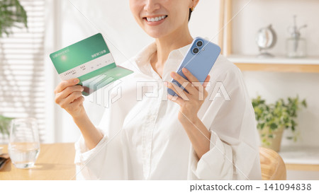 Middle-aged woman looking at her bankbook Middle-aged woman looking at her bankbook 141094838