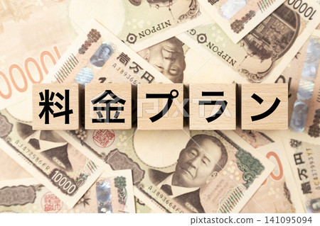 A block with "Pricing Plan" written on it and lots of 10,000 yen bills. A block with "Pricing Plan" written on it and lots of 10,000 yen bills. 141095094