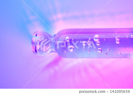 Serum in glass pipette with bubbles and neon colors Serum in glass pipette with bubbles and neon colors 141095639