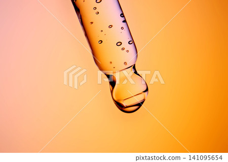 Serum drop falling from a pipette for skincare Serum drop falling from a pipette for skincare 141095654