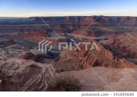 Vast desert canyon panorama in utah, usa, showcasing impressive red rock formation. winding river below carves through dramatic landscape, inspiring profound wonder and peaceful reflection Vast desert canyon panorama in utah, usa, showcasing impressive red rock formation. winding river below carves through dramatic landscape, inspiring profound wonder and peaceful reflection 141095689