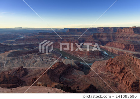 Majestic river gracefully carves winding path through ancient red rock canyon vast desert landscape of utah usa. Breathtaking panoramic view unfolds, revealing timeless natural beauty evoking awe Majestic river gracefully carves winding path through ancient red rock canyon vast desert landscape of utah usa. Breathtaking panoramic view unfolds, revealing timeless natural beauty evoking awe 141095690