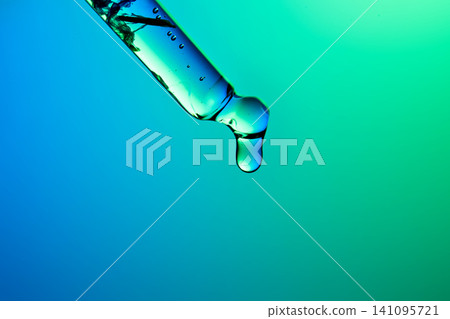 Biotech skincare serum drop falling from pipette Biotech skincare serum drop falling from pipette 141095721