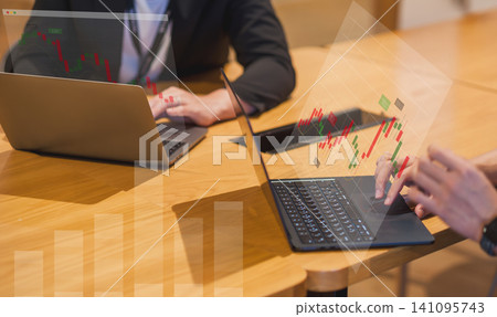 A scene from a business team meeting where they are reviewing stock price charts; stock trading and investment imagery. A scene from a business team meeting where they are reviewing stock price charts; stock trading and investment imagery. 141095743