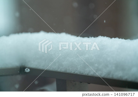 A close-up of the fluffy, freshly fallen snow on the balcony railing. A close-up of the fluffy, freshly fallen snow on the balcony railing. 141096717