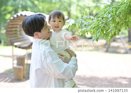 A young father holding his beloved daughter in his arms. A young father holding his beloved daughter in his arms. 141097135