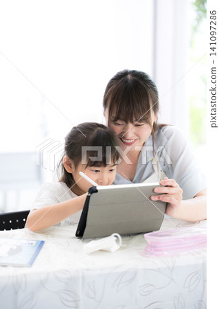 A mother and elementary school girl learning together using a tablet - A lifestyle of parent-child learning at home (view screen) A mother and elementary school girl learning together using a tablet - A lifestyle of parent-child learning at home (view screen) 141097286