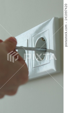 Vertical video Man hands of electrician dismantling old socket using screwdriver. Replacing electrical outlet. Installing. Repair. Electricity. Vertical video Man hands of electrician dismantling old socket using screwdriver. Replacing electrical outlet. Installing. Repair. Electricity. 141097420