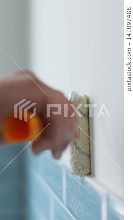 Vertical video Man worker using roller to paint the walls in the house in white color. Room renovations at house. Vertical video Man worker using roller to paint the walls in the house in white color. Room renovations at house. 141097488