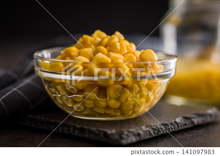 Glass Bowl of Sweet Corn Kernels on Slate Board With Rustic Dark Background, Close-Up Food Photo Glass Bowl of Sweet Corn Kernels on Slate Board With Rustic Dark Background, Close-Up Food Photo 141097983