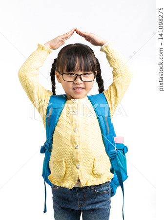 A sweet little girl forming a roof shape over her head with her hands while smiling. 141098275
